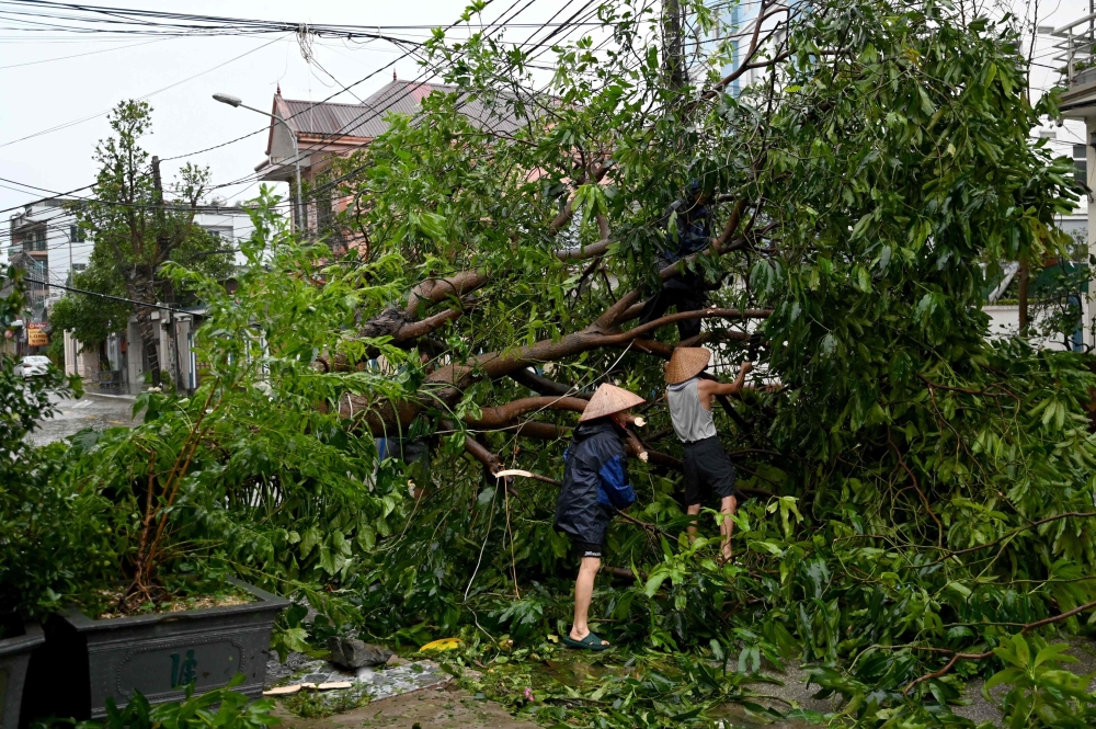 People clear up rubbles after Typhoon Kajiki passed through in Nghe An province on August 26, 2025.
