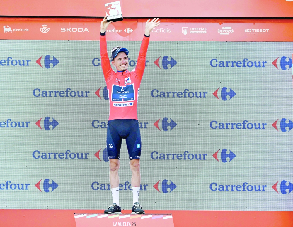 Team Groupama-FDJ's French rider David Gaudu celebrates on the podium wearing the overall leader's red jersey after the fourth stage of the Vuelta a Espana. — AFP