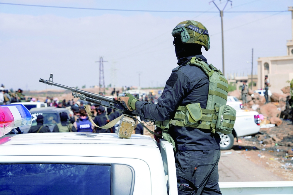 A member of the Syrian Internal Security Forces holds a gun at a checkpoint. — AFP file photo