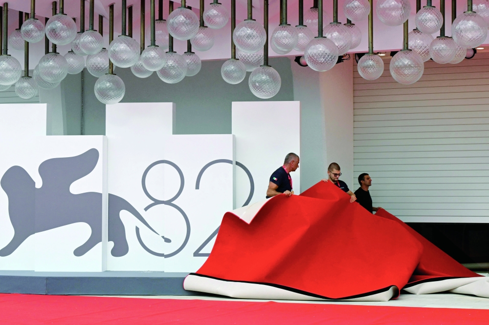 Workers set the red carpet at the Palazzo del Cinema ahead of the opening ceremony of the 82nd Venice Film Festival at Venice Lido, on August 26, 2025.  (Photo by Stefano RELLANDINI / AFP)
