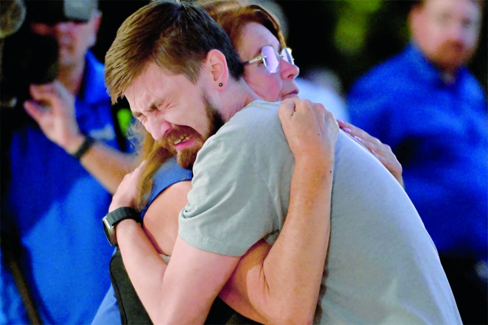 Mourners become emotional as they embrace during a vigil at Academy of Holy Angels in Richfield, Minnesota, for the victims of a mass shooting at Annunciation Catholic Church and School in Minneapolis. — AFP
