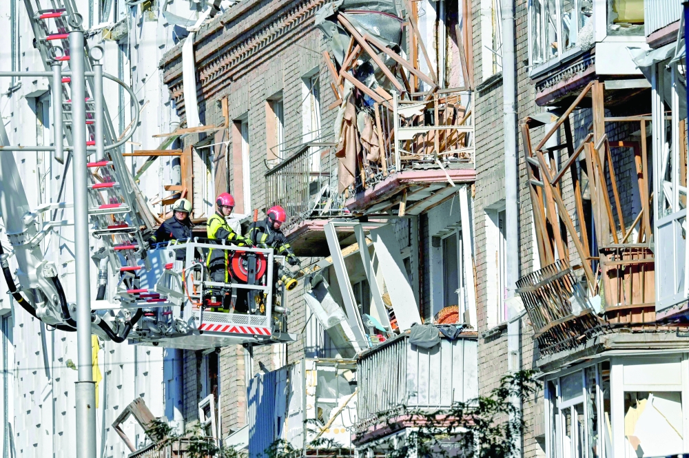 Rescuers clear debris in a residential building in a damaged area following a large-scale Russian drone and missile attacks in Kyiv amid the Russian war in Ukraine. - AFP