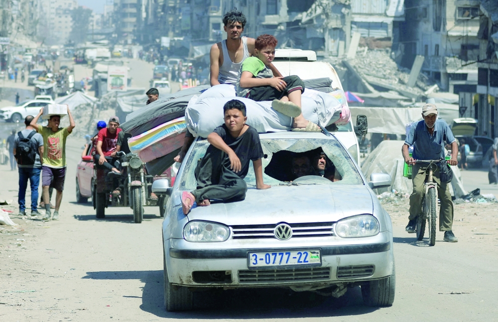 Displaced Palestinians flee from one area to another in Gaza City on Thursday. — Reuters