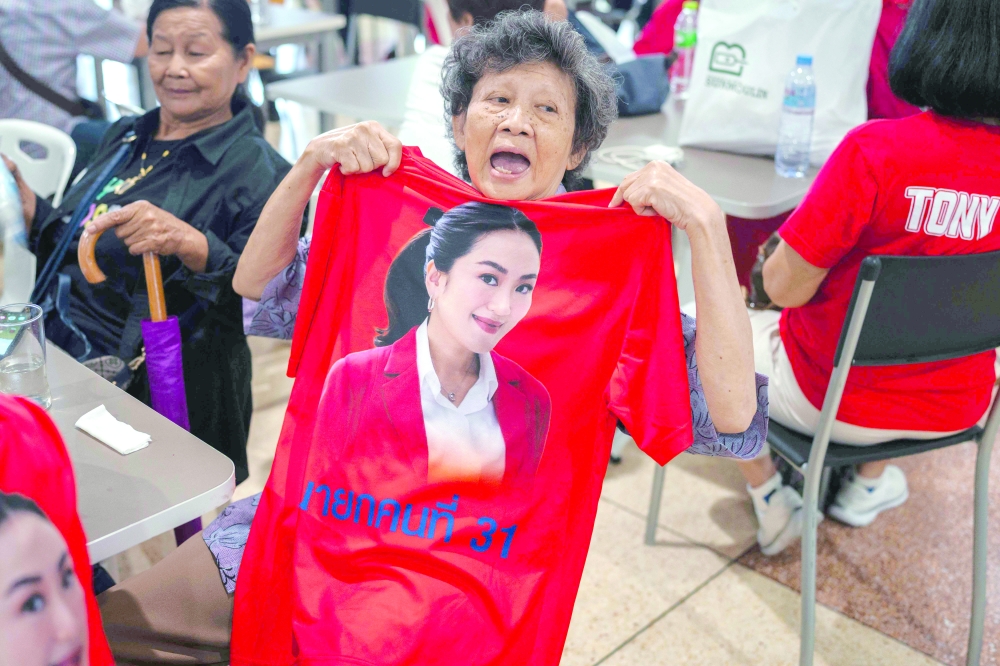 A supporter of Thailand's sacked prime minister Paetongtarn Shinawatra reacts after the ruling on her dismissal by the Constitutional Court at the Pheu Thai Party headquarters in Bangkok. — AFP