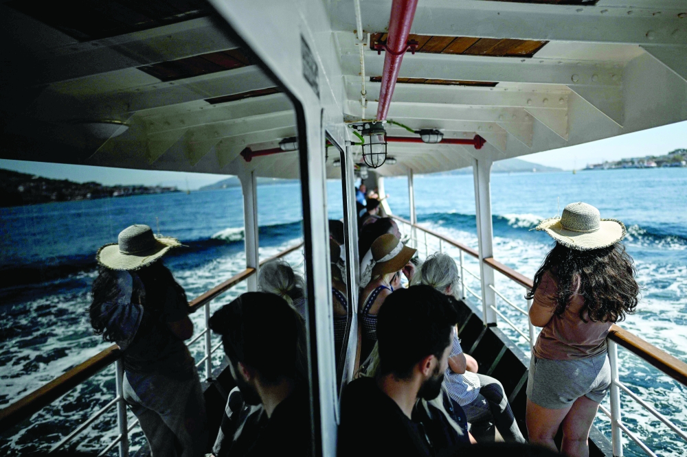 Passengers sail aboard the Pasabahce ferryboat to Princes islands in Istanbul, on August 21, 2025. For nearly two centuries, the white ferries gliding over the Bosphorus have provided an iconic link for countless passengers travelling between Istanbul's European shores and its Asian side.