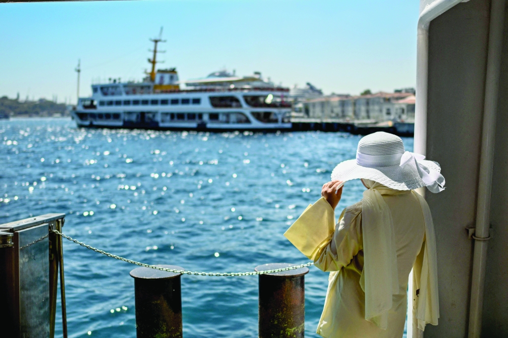 A passenger waits on the Pasabahce ferryboat docked at Kabatas port in Istanbul, on August 21, 2025. For nearly two centuries, the white ferries gliding over the Bosphorus have provided an iconic link for countless passengers travelling between Istanbul's European shores and its Asian side. 

