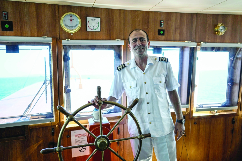 Captain Ekrem Ozcelik poses on the Pasabahce ferryboat at Kabatas port in Istanbul, on August 21, 2025. For nearly two centuries, the white ferries gliding over the Bosphorus have provided an iconic link for countless passengers travelling between Istanbul's European shores and its Asian side. 

