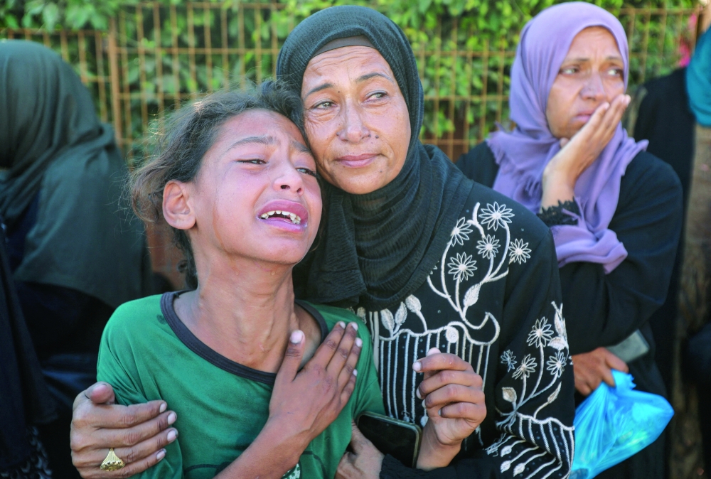 Mourners react during the funeral of Palestinians, in Khan Yunis. — Reuters