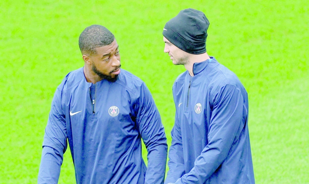 Paris Saint-Germain's French defender #03 Presnel Kimpembe (L) and Paris Saint-Germain's Spanish midfielder #08 Fabian Ruiz (R) arrive for a training session at the club's training camp in Poissy, west of Paris, on August 29, 2025.