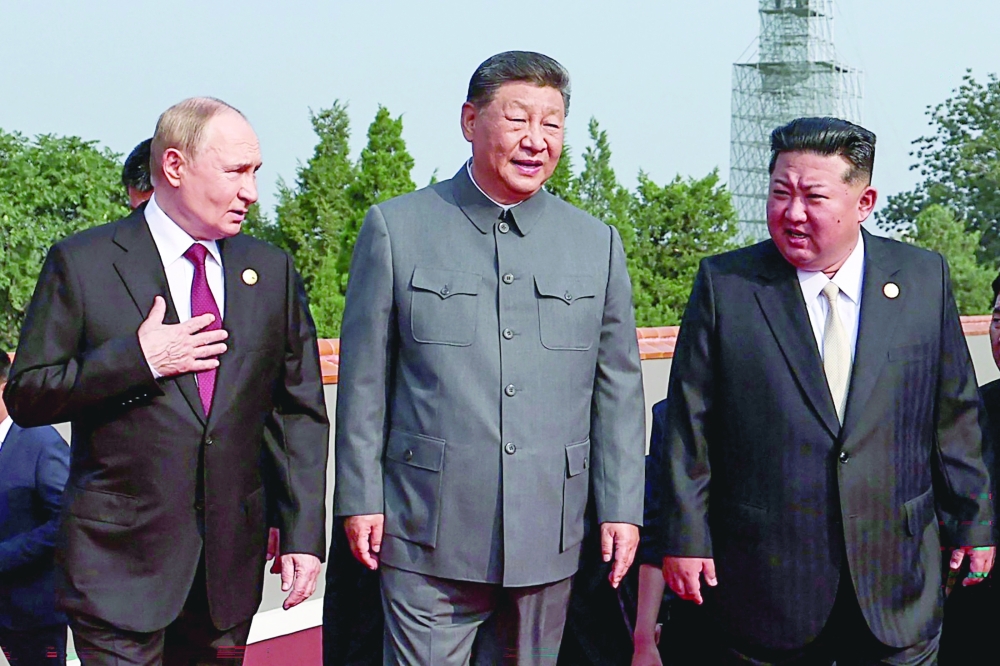 Russia's President Vladimir Putin walks with China's President Xi Jinping and North Korea's leader Kim Jong Un before a military parade in Beijing on Wednesday. — AFP