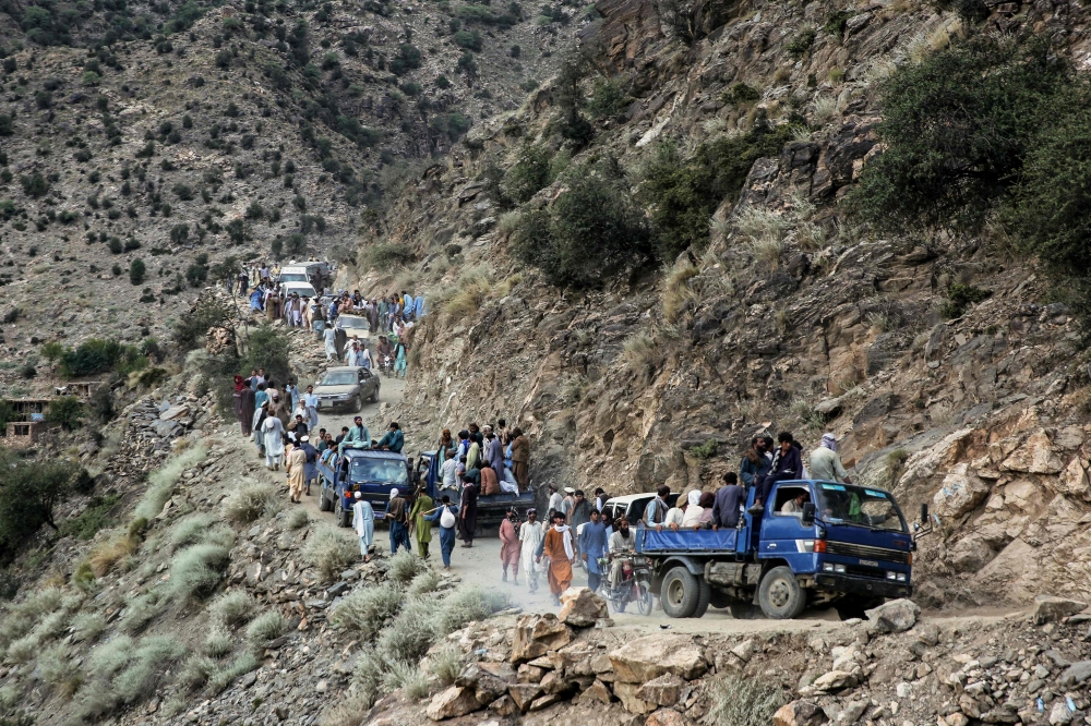 Afghans walk along a hillside, in the aftermath of an earthquake at the Nurgal district of Kunar province on September 3, 2025. 