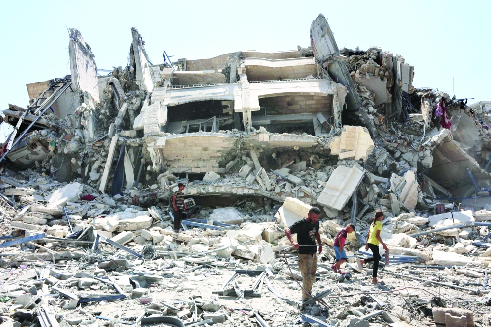 Palestinians check the debris of the Mushtaha Tower in Gaza City following an Israeli military strike. — Reuters