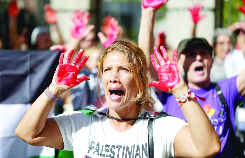 A protester shows her red-tainted hands during a pro-Palestinian demonstration in front of the Israeli Embassy in Madrid, on September 6, 2025. Israel's retaliatory offensive to the 2023 Hamas attacks has killed at least 64,300 Palestinians, most of them civilians, according to figures from the health ministry in Hamas-run Gaza that the United Nations considers reliable. Hamas's 2023 attack resulted in the deaths of 1,219 people, mostly civilians, according to a tally based on official figures. Hamas also took 251 hostages.