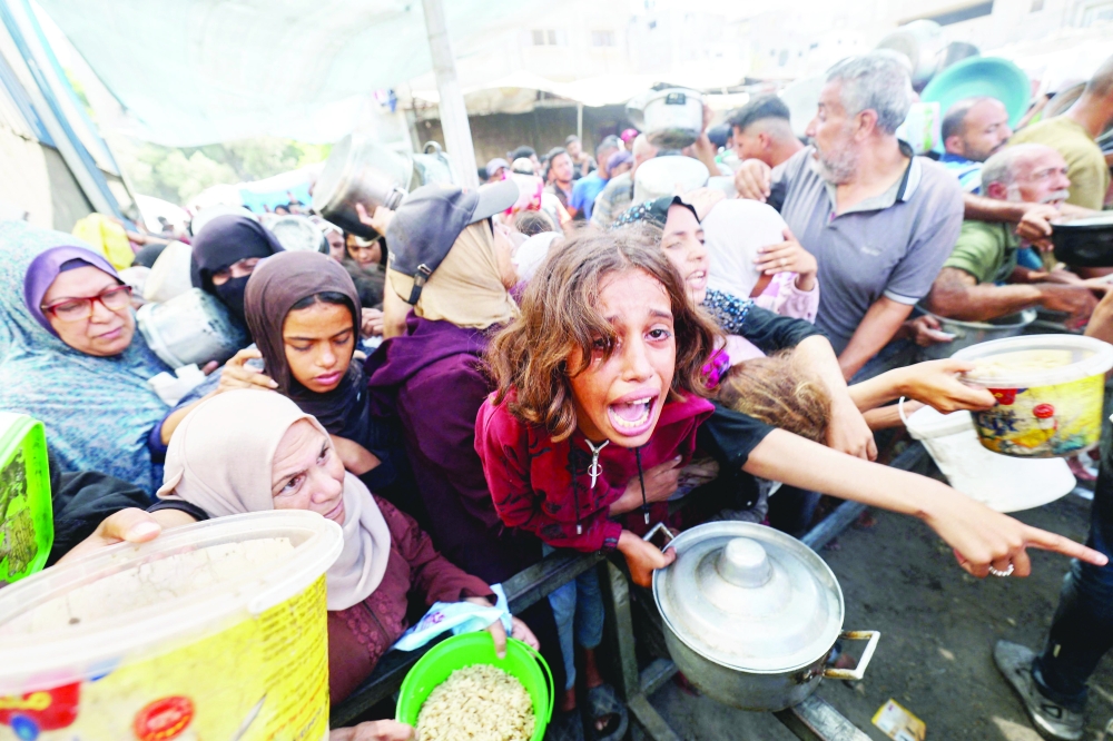 Palestinians shove to receive a hot meal from a charity kitchen in the Nuseirat refugee camp in the Israel-besieged Gaza Strip on September 4, 2025, where the UN has declared famine after nearly two years of war.