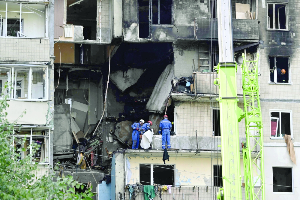 Ukrainian rescuers work at the site of a heavily damaged building, in Kyiv. — AFP