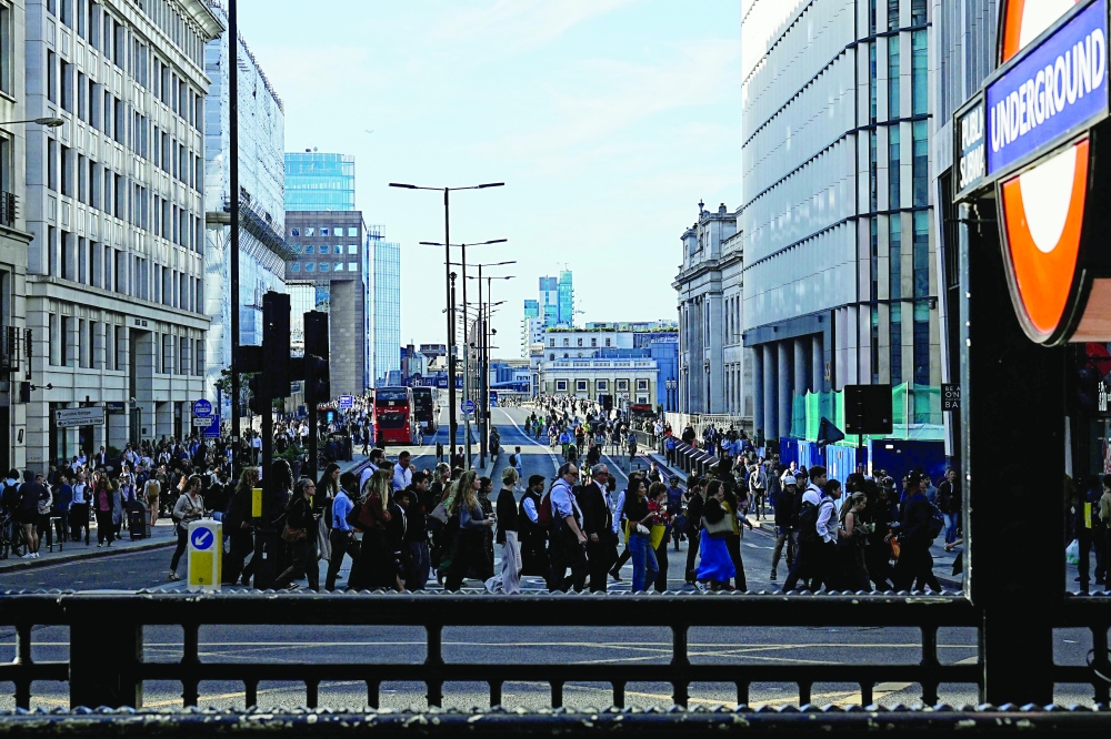 Commuters cross London Bridge early in the morning. — AFP