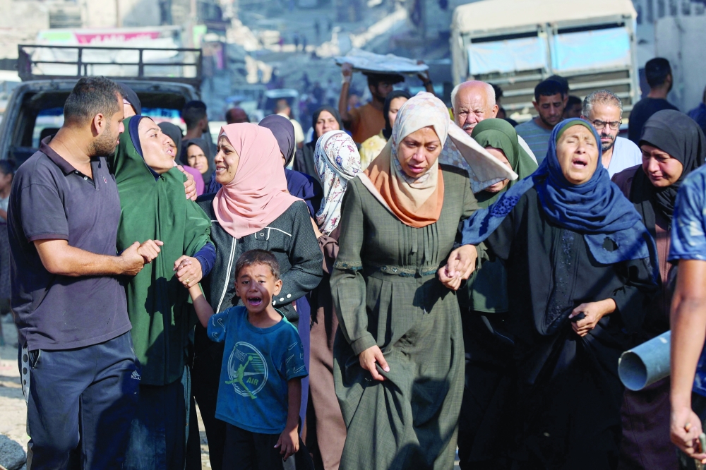 Palestinians cry as they walk outside Al Shifa Hospital in Gaza City. — AFP