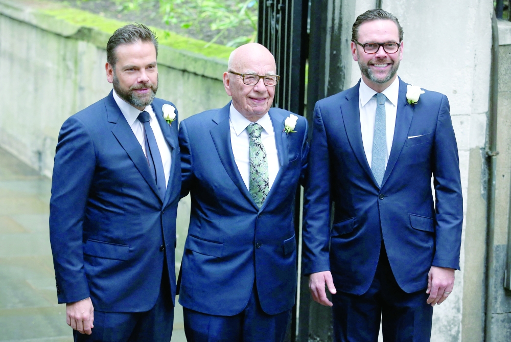 Media magnate Rupert Murdoch (C) flanked by his sons Lachlan (L) and James (R) appear at St Bride's church on Fleet Street in central London. — AFP file photo
