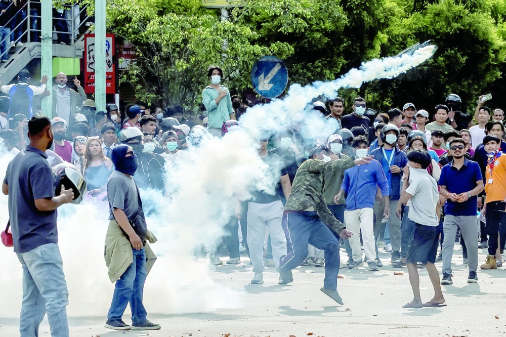 Demonstrators clash with riot police personnel outside the Parliament in Kathmandu. — AFP