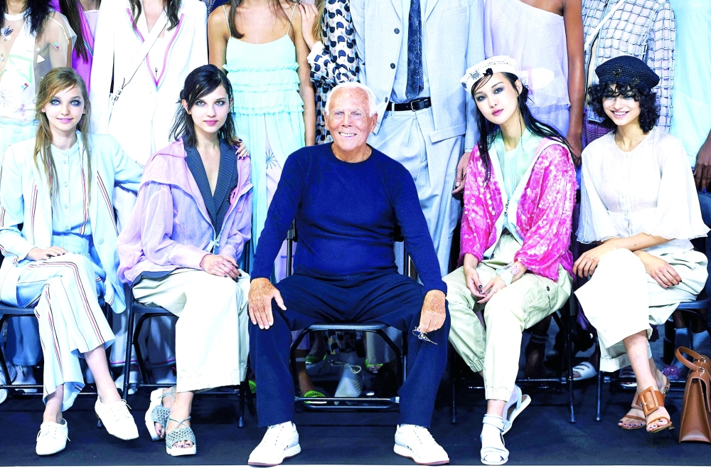 Italian designer Giorgio Armani poses for a photograph next to models after the fashion house Emporio Armani catwalk show for the Spring/Summer 2018 collection on the third day of The London Fashion Week Women's in London on September 17, 2017. Italian fashion great Giorgio Armani has died at the age of 91 "surrounded by his loved ones", his company said on September 4, 2025. (Photo by Niklas HALLE'N / AFP)
