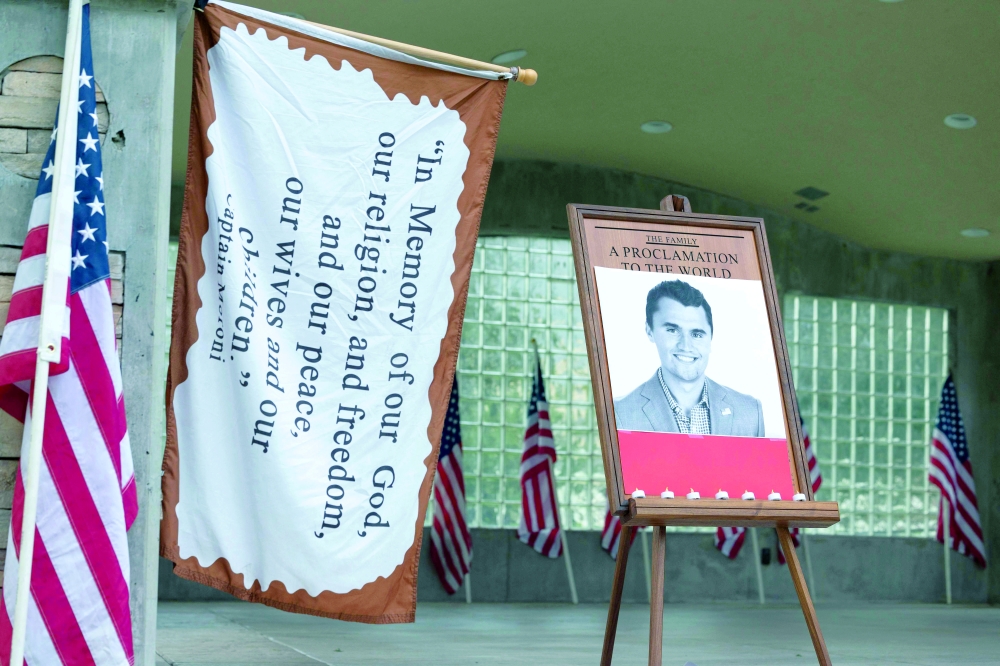 Candles are left in front of a photo of youth activist and influencer Charlie Kirk as people attend a vigil in Orem City Centre Park, Orem, Utah. — AFP