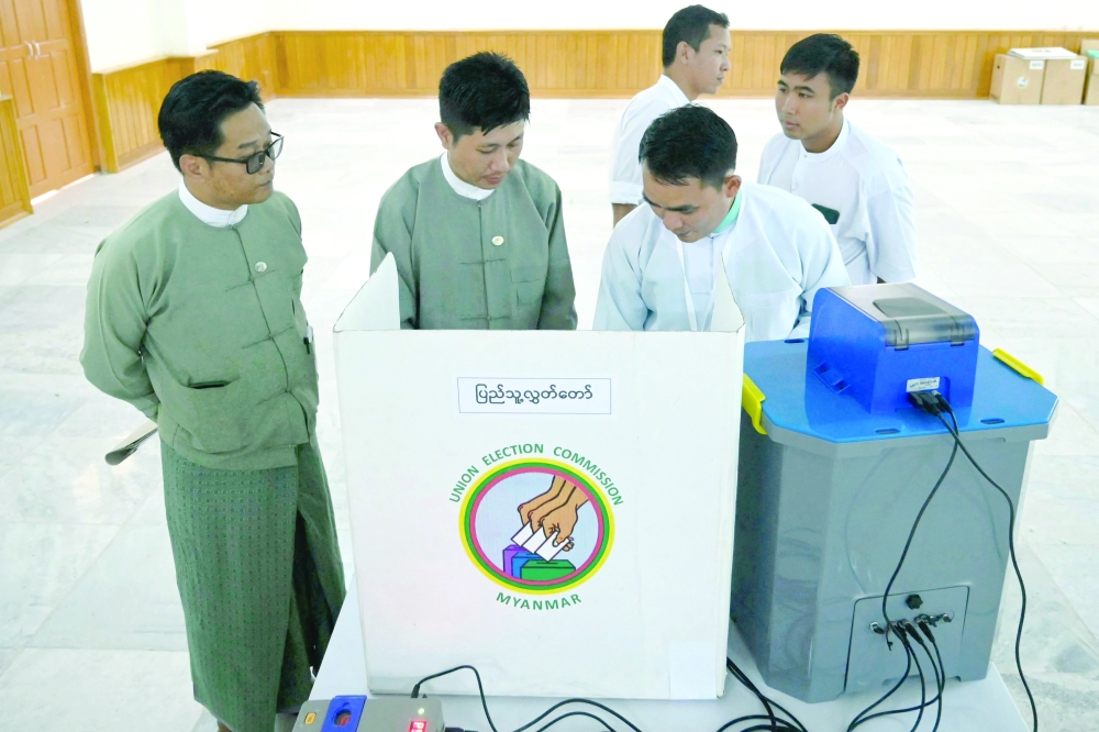 Members of Myanmar's Union Election Commission demonstrate a voting machine during the UEC's first major press conference in Naypyidaw. - AFP