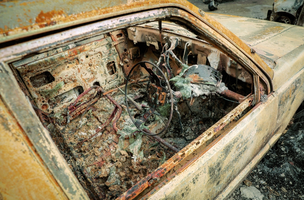 A burnt car is pictured inside the Singha Durbar office complex that houses the Prime Minister's office and other ministries, in Kathmandu. — Reuters
