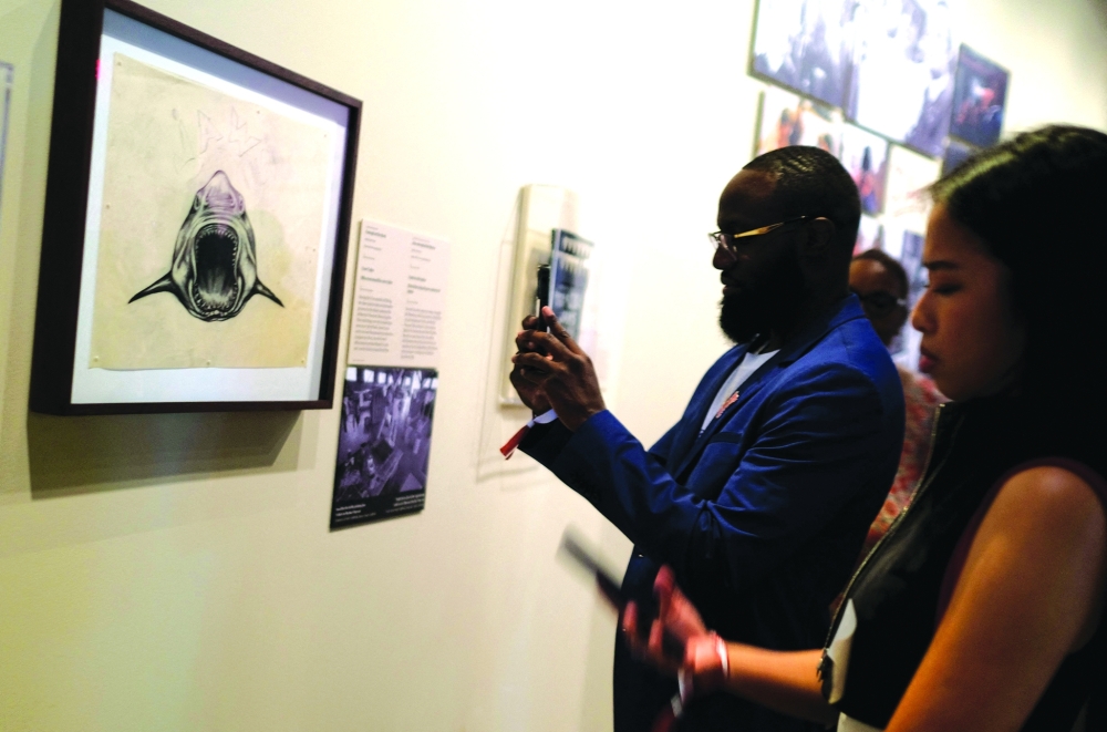 Attendees take pictures of art during a media preview of “Jaws: The Exhibition” at the Academy Museum of Motion Pictures in Los Angeles on September 10, 2025.