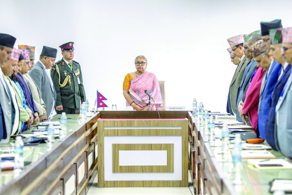 Newly-elected PM of Nepal's interim government Sushila Karki (C), along with officials, observes a moment of silence, in Kathmandu. — AFP