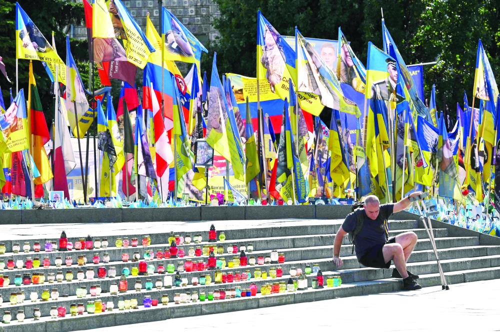 A wounded Ukrainian serviceman is seen at a makeshift memorial for fallen soldiers, in Kyiv. — AFP