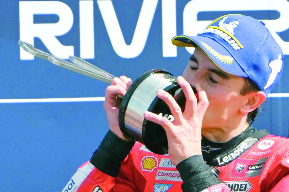 Ducati Lenovo Team's Spanish MotoGP rider Marc Marquez kisses his trophy as he celebrates his victory on the podium at the end of the San Marino Moto GP Grand Prix. — AFP