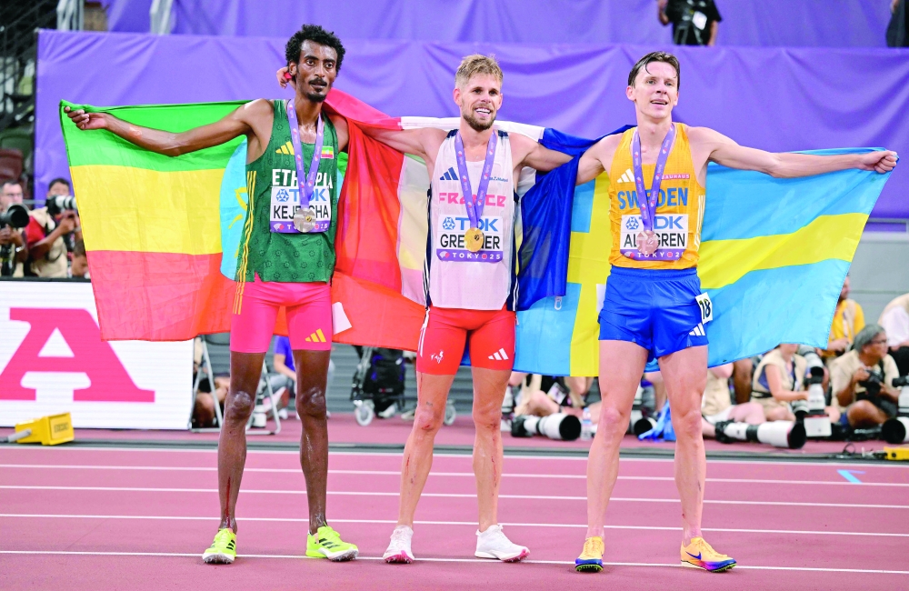 (L-R) Second-placed Ethiopia's athlete Yomif Kejelcha, winner France's athlete Jimmy Gressier, and third-placed Sweden's athlete Andreas Almgren celebrate with their medals and coutries' flags after competing in the men's 10000m final during the World Athletics Championships in Tokyo. — AFP