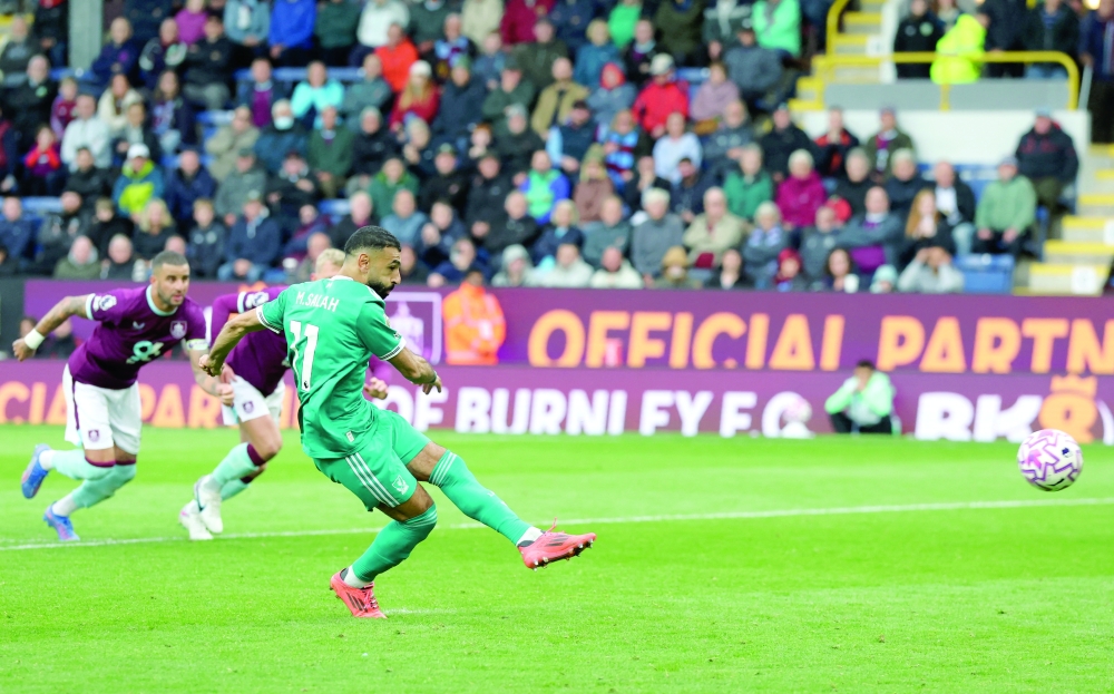 Liverpool's Mohamed Salah scores their first goal from the penalty spot. — Reuters