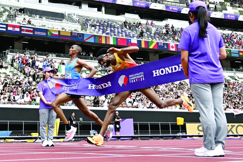 TOPSHOT - Tanzania's athlete Alphonce Felix Simbu and Germany's athlete Amanal Petros (C) cross the finish line in the men's marathon final during the World Athletics Championships in Tokyo on September 15, 2025. (Photo by Jewel SAMAD                          / AFP)
