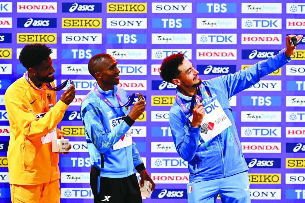 (L-R) Silver medallist Germany's athlete Amanal Petros, gold medallist Tanzania's Alphonce Felix Simbu and bronze medallist Italy's athlete Iliass Aouani pose with their medals on the podium for the men's marathon during the World Athletics Championships in Tokyo on September 15, 2025.  (Photo by Philip FONG / AFP)
