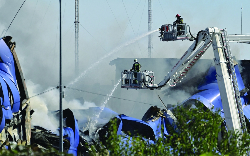 Ukrainian rescuers work to extinguish a fire at the site of a drone attack, in Kyiv. — AFP