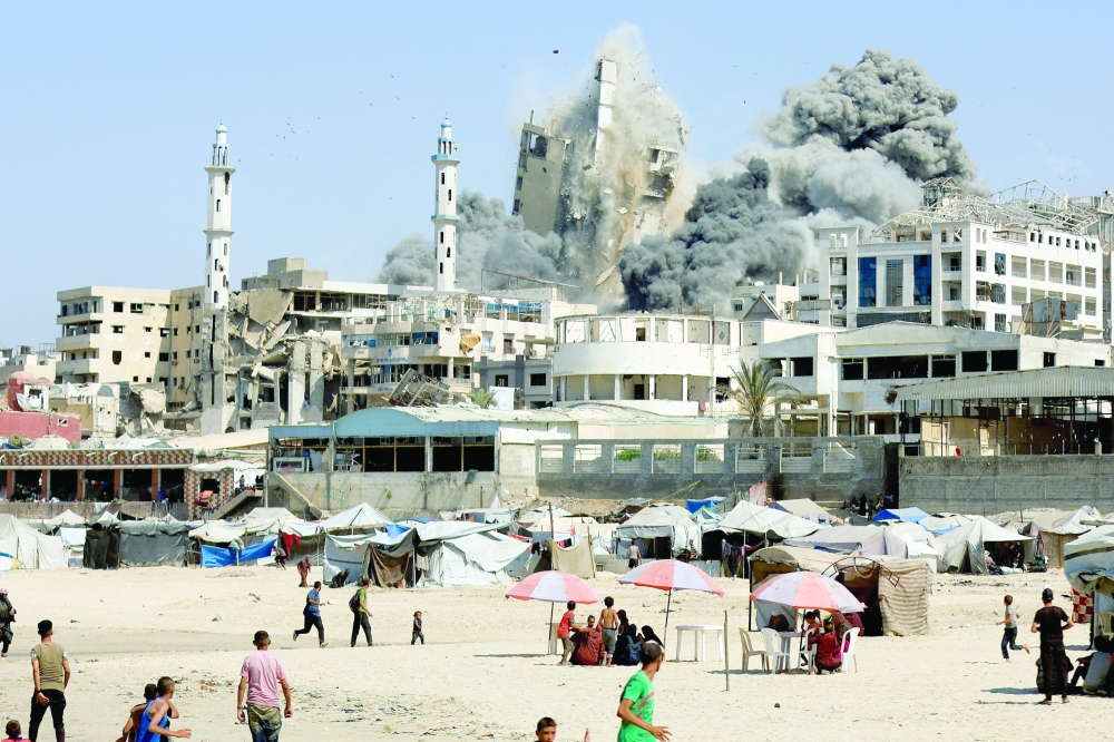 Smoke rises from the evacuated Al Ghefari tower, as it collapses after it was hit by Israeli air strikes, in Gaza. — Reuters