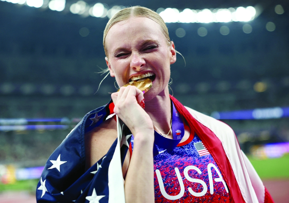 World Athletics Championships Tokyo 2025 - Women's Pole Vault Final - Japan National Stadium, Tokyo, Japan - September 17, 2025 Katie Moon of the U.S. celebrates winning gold with her medal and national flag REUTERS/Eloisa Lopez