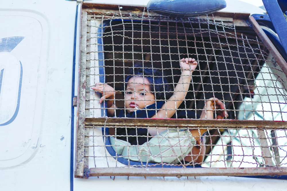 A displaced Palestinian child looks out of truck while moving southward after Israeli forces ordered residents of Gaza City to evacuate to the south, in the central Gaza Strip. - Reuters