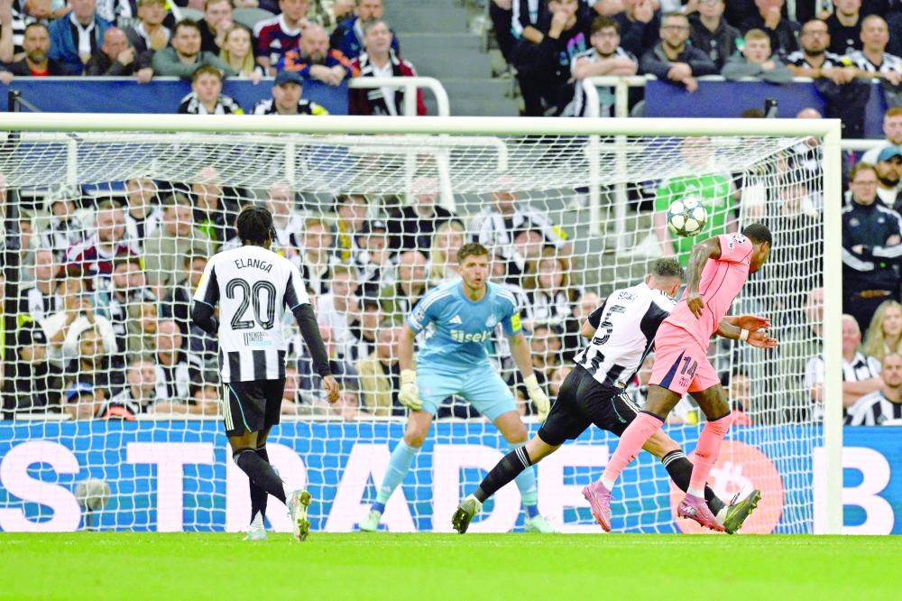 Barcelona's British forward #14 Marcus Rashford (R) heads the ball to score his team's first goal during the UEFA Champions League first round football match between Newcastle United FC and FC Barcelona at St James' Park in London, on September 18, 2025. (Photo by Oli SCARFF / AFP)