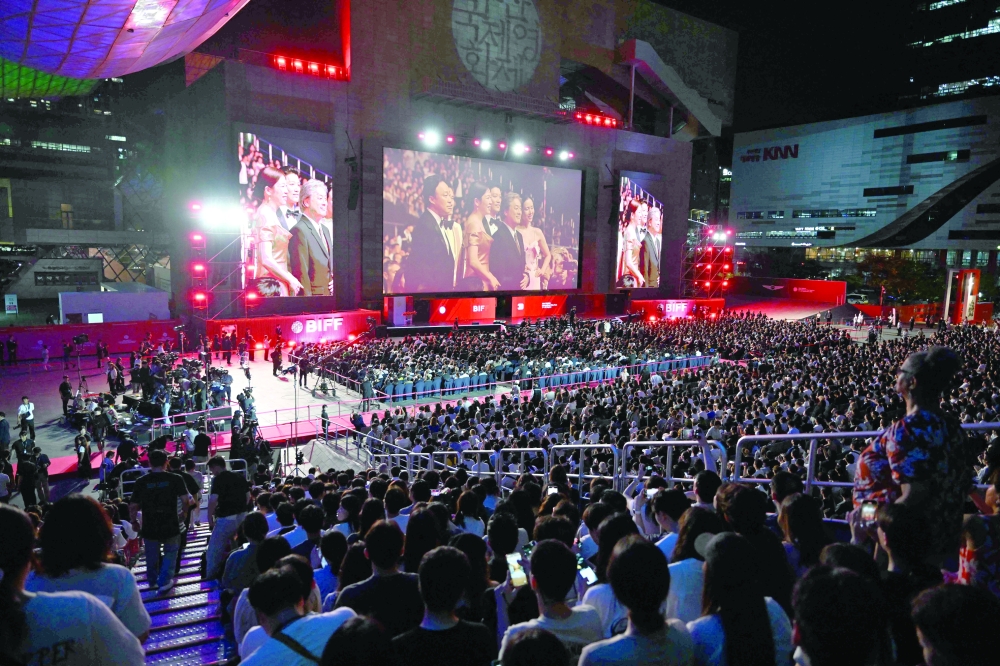 (on the screen) South Korean director Park Chan-wook and actors Lee Byung-hun, Son Ye-jin, Park Hee-soon, Lee Sung-min and Yeom Hye-ran walk on the red carpet during the opening ceremony of the 30th Busan International Film Festival (BIFF) at the Busan Cinema Center in Busan on September 17, 2025.