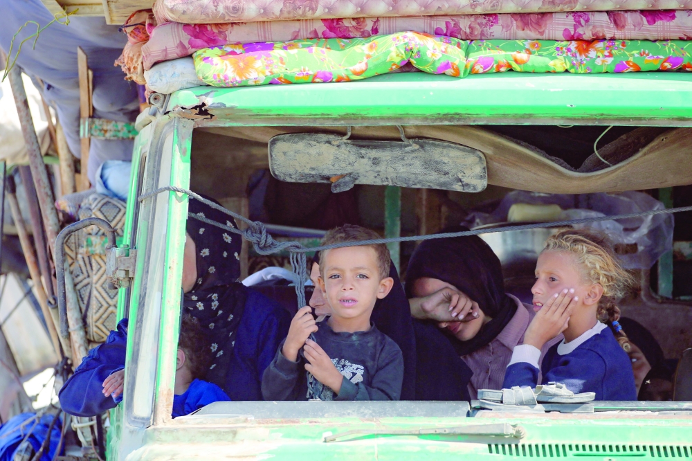 Palestinians ride in a truck as they move southwards with their belongings. — AFP