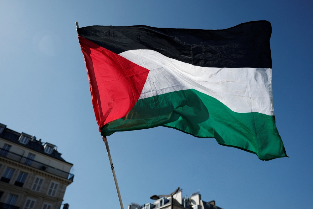 A Palestinian flag flies during a protest in front of the Gare du Nord railway station in Paris