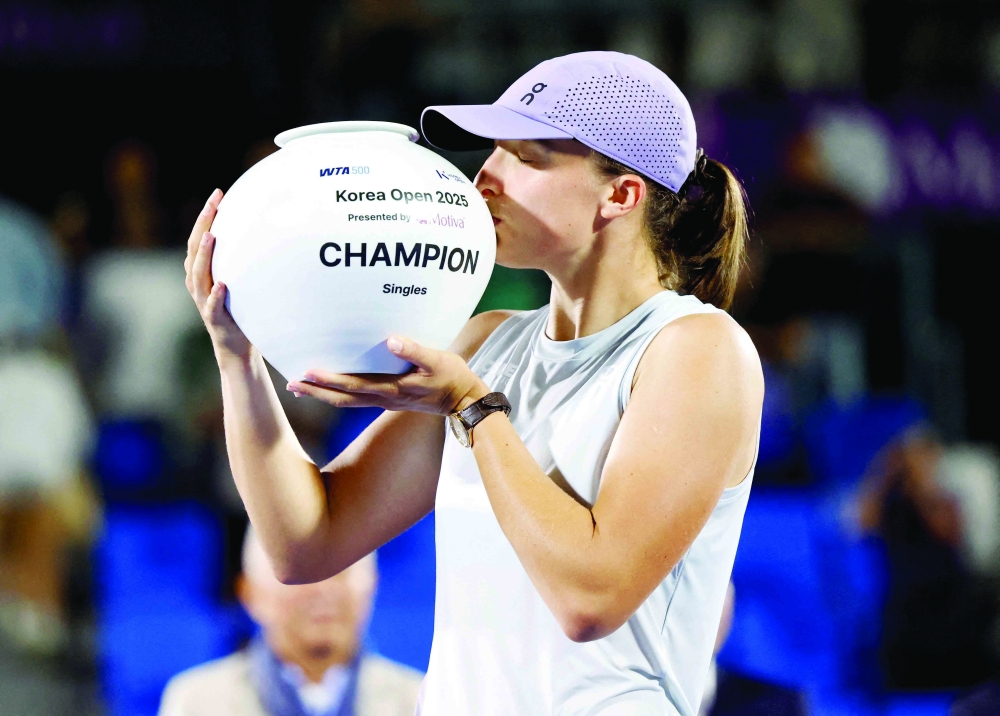  Poland's Iga Swiatek celebrates with the trophy after winning her singles final against Russia's Ekaterina Alexandrova. — Reuters