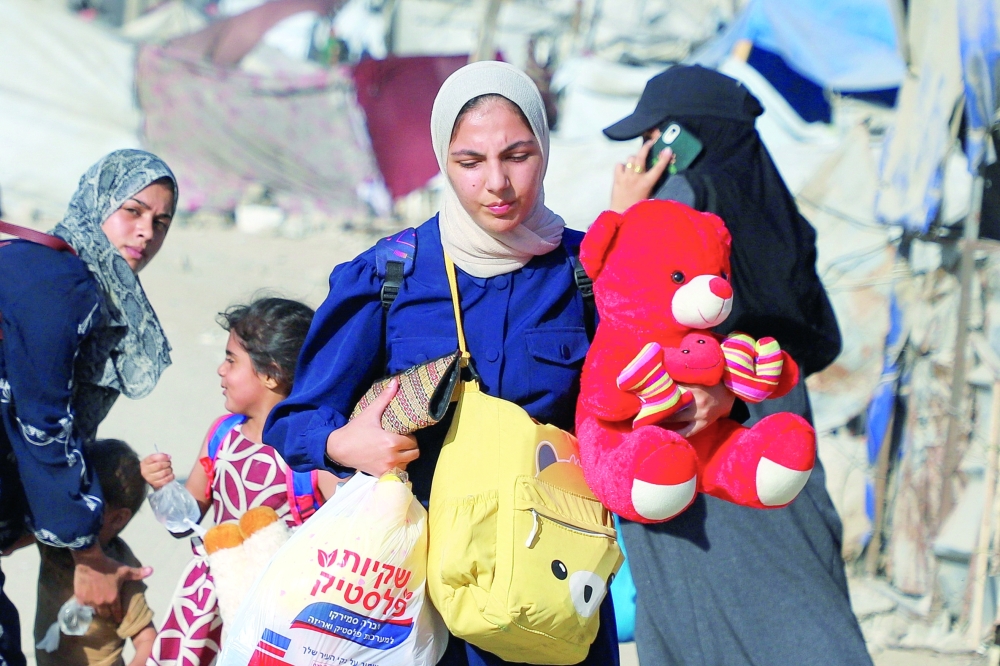 Displaced Palestinians flee amid an Israeli military operation in Gaza City to evacuate to the south on Sunday. — Reuters