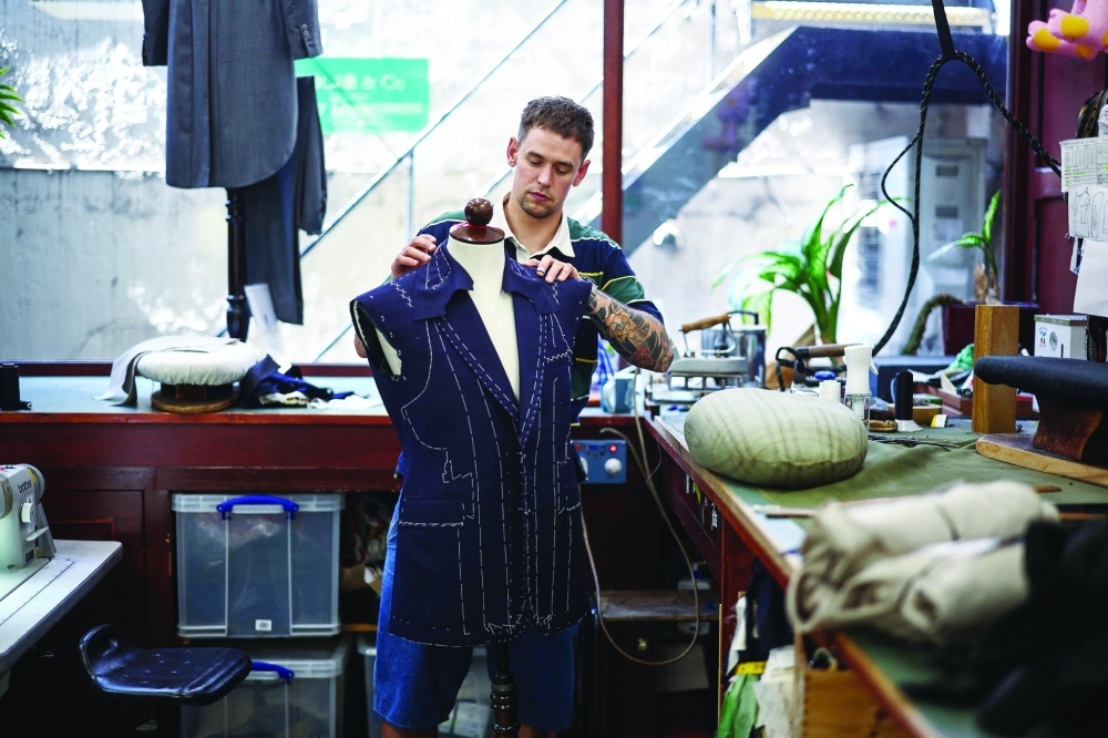 Apprentice tailor Henry makes adjustments to a waist coat at Henry Poole & Co on Savile Row in London on August 12, 2025. Beneath the old-world exterior of a tailors on London's famed Savile Row, the workshop where the magic happens is more youthful than ever as aspiring coatmakers vie for competitive apprenticeships.
 (Photo by HENRY NICHOLLS / AFP)
