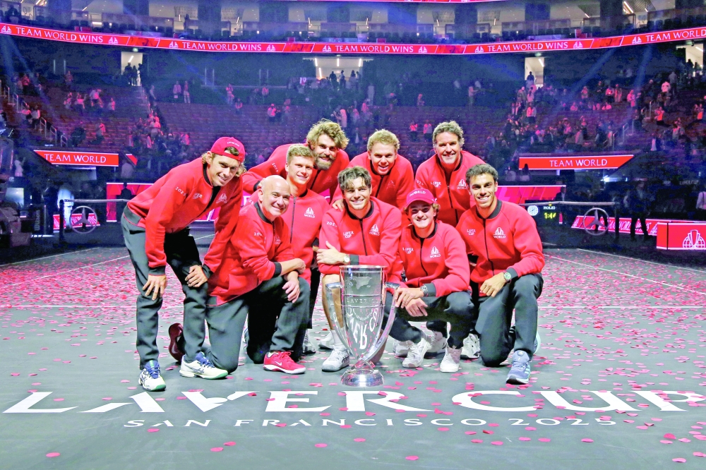 Team World player Alex de Menaur, captain Andre Agassi, players Jenson Brooksby, Reilly Opelka, Taylor Fritz, Alex Michelsen, Joao Fonseca, vice captain Patrick Rafter, and player Francisco Cerundulo celebrate with the Laver Cup trophy after defeating Team Europe at the Laver Cup. — Imagn Images