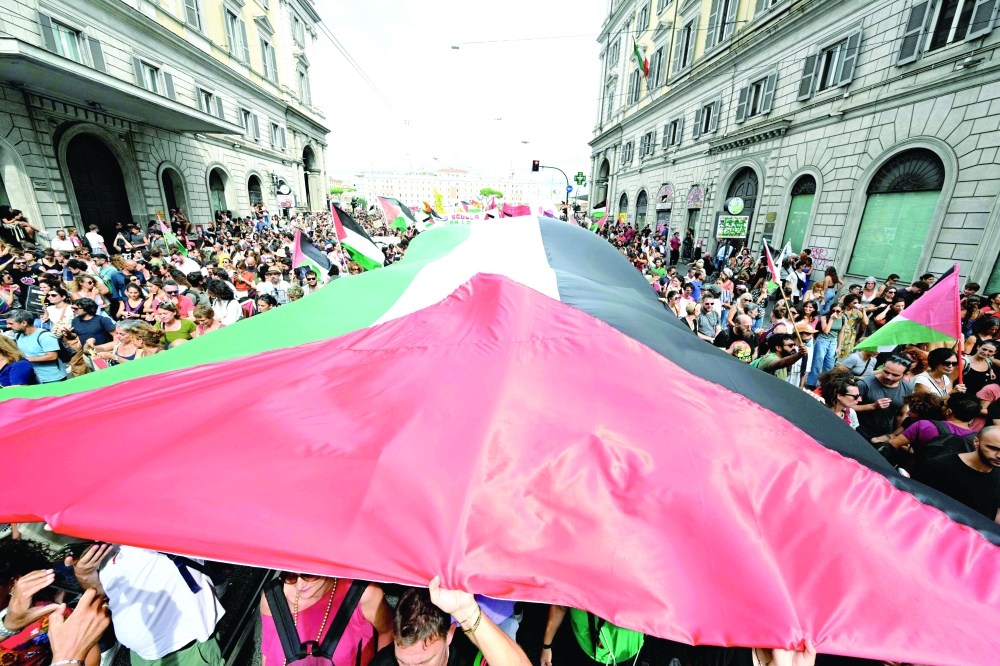 People march with a giant Palestinian flag during a nationwide strike, "Let's Block Everything", in Rome. — AFP