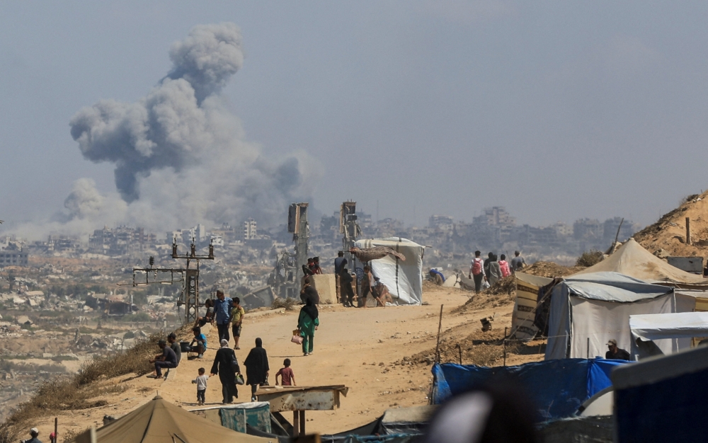Smoke rises from an Israeli strike in the central Gaza Strip as displaced Palestinians flee northern Gaza