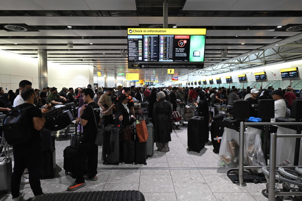 Travellers wait in terminal 4 at Heathrow Airport, west of London. — AFP file photo